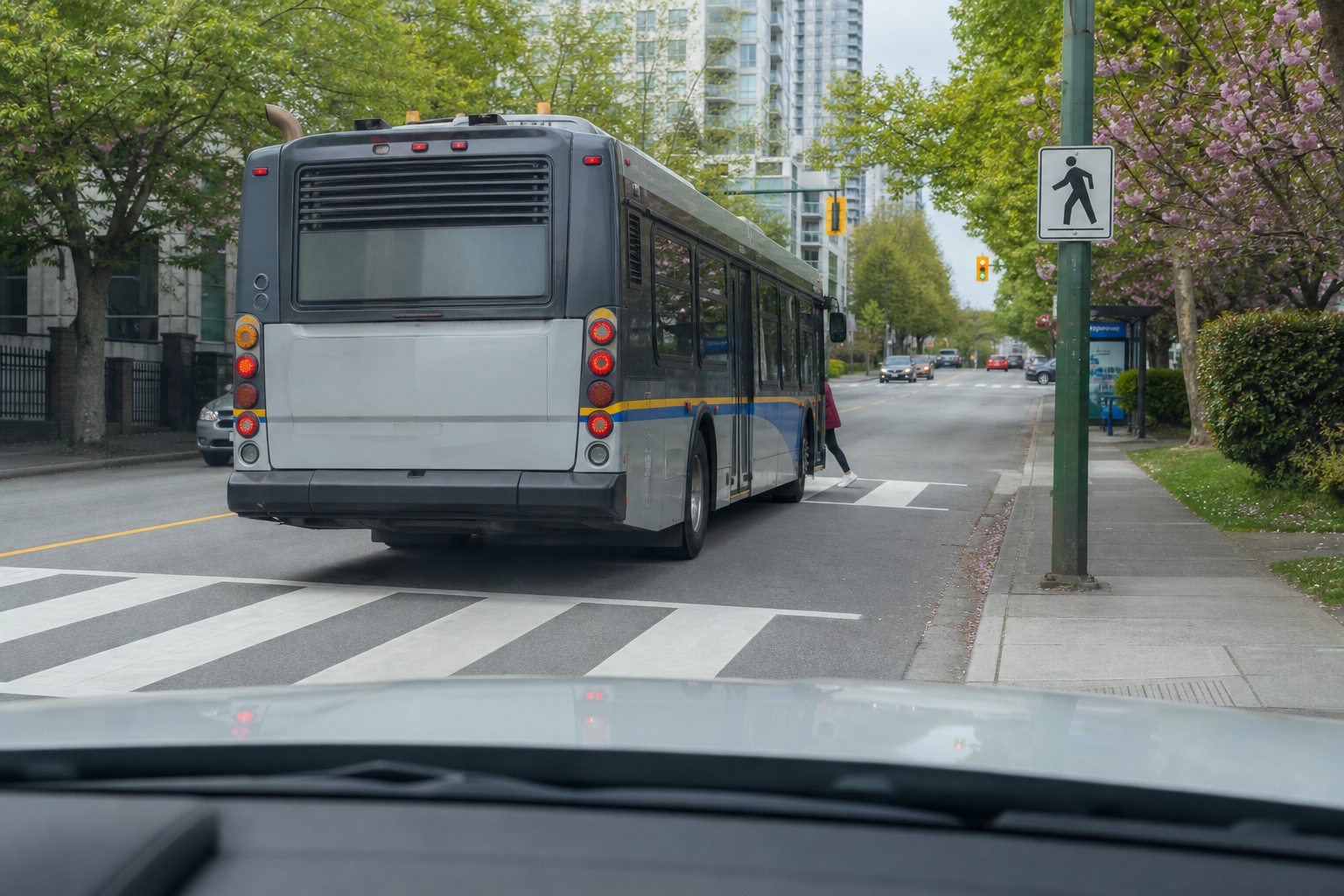 In the image, a stopped bus blocks your view of a crosswalk area. What should you be prepared for?